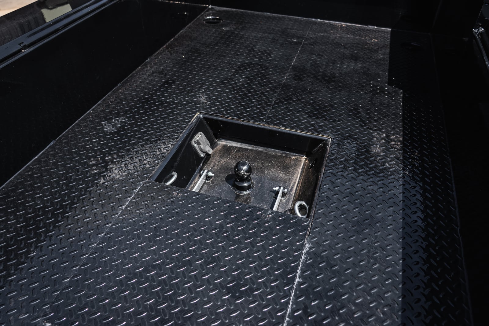 Recessed gooseneck ball and safety-chain points in the Apollo treadplate deck.