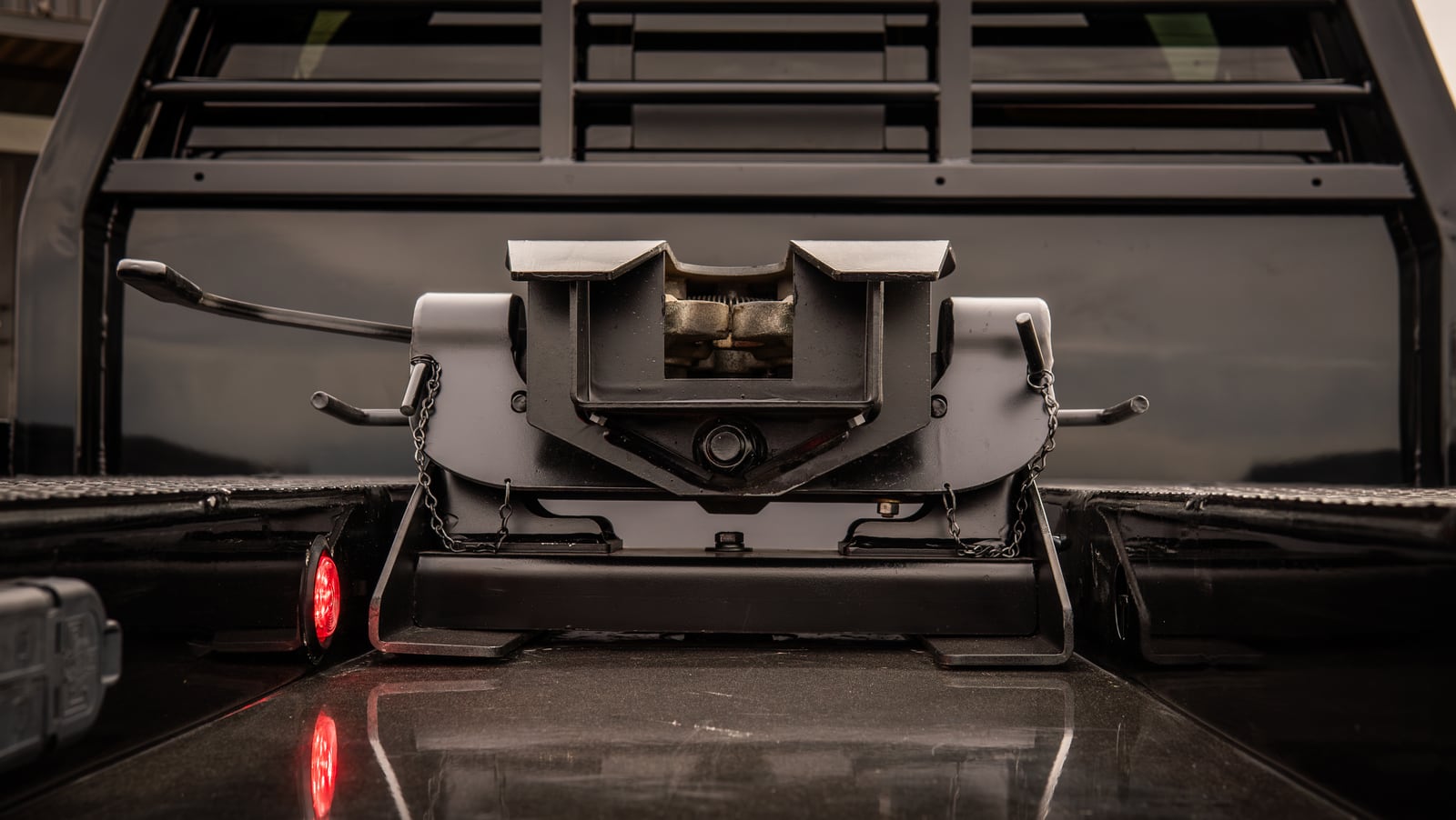 Rear detail of a black Legend X Phoenix bed with the gooseneck hitch area visible.
