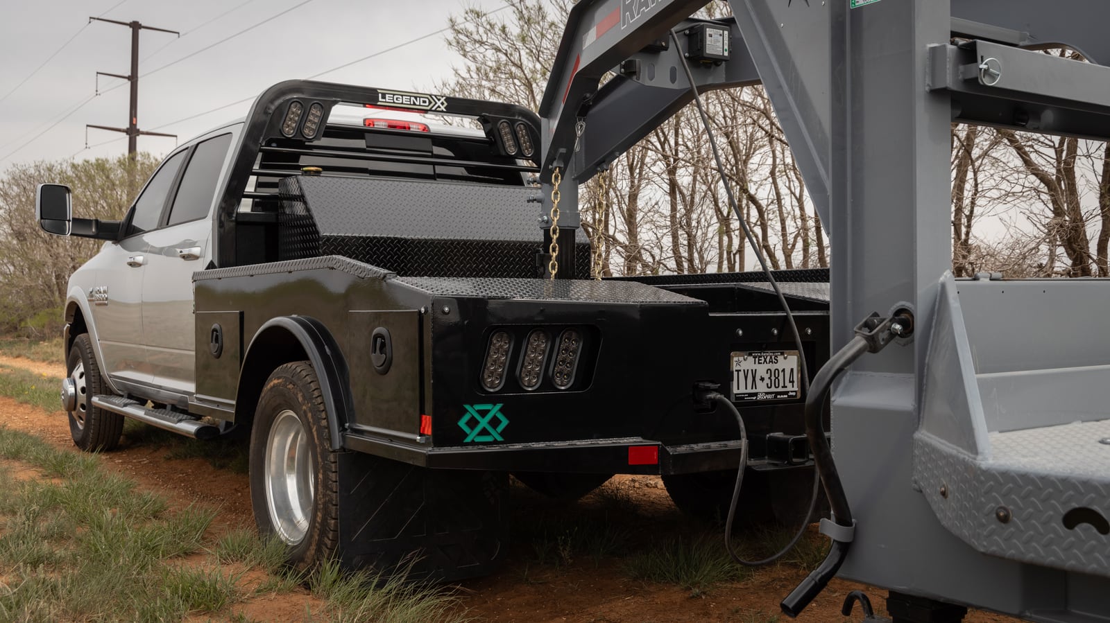 Black Legend X Phoenix bed connected to a gooseneck trailer on a silver pickup.