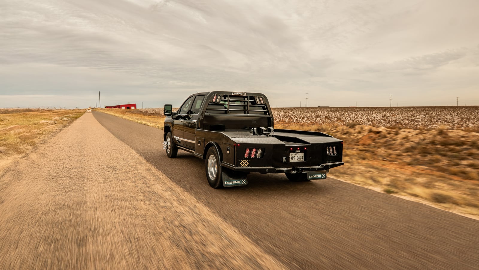 Black Chevrolet dually fitted with a black Legend X Phoenix bed on a rural road.