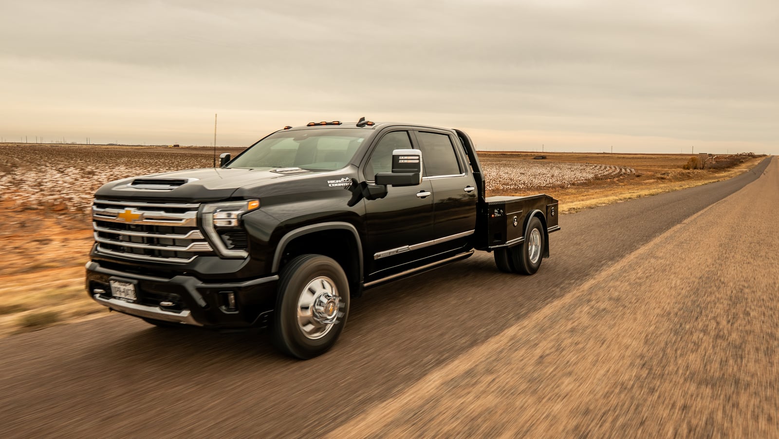 Black Chevrolet dually with a black Legend X Phoenix bed in a rolling front three-quarter view.