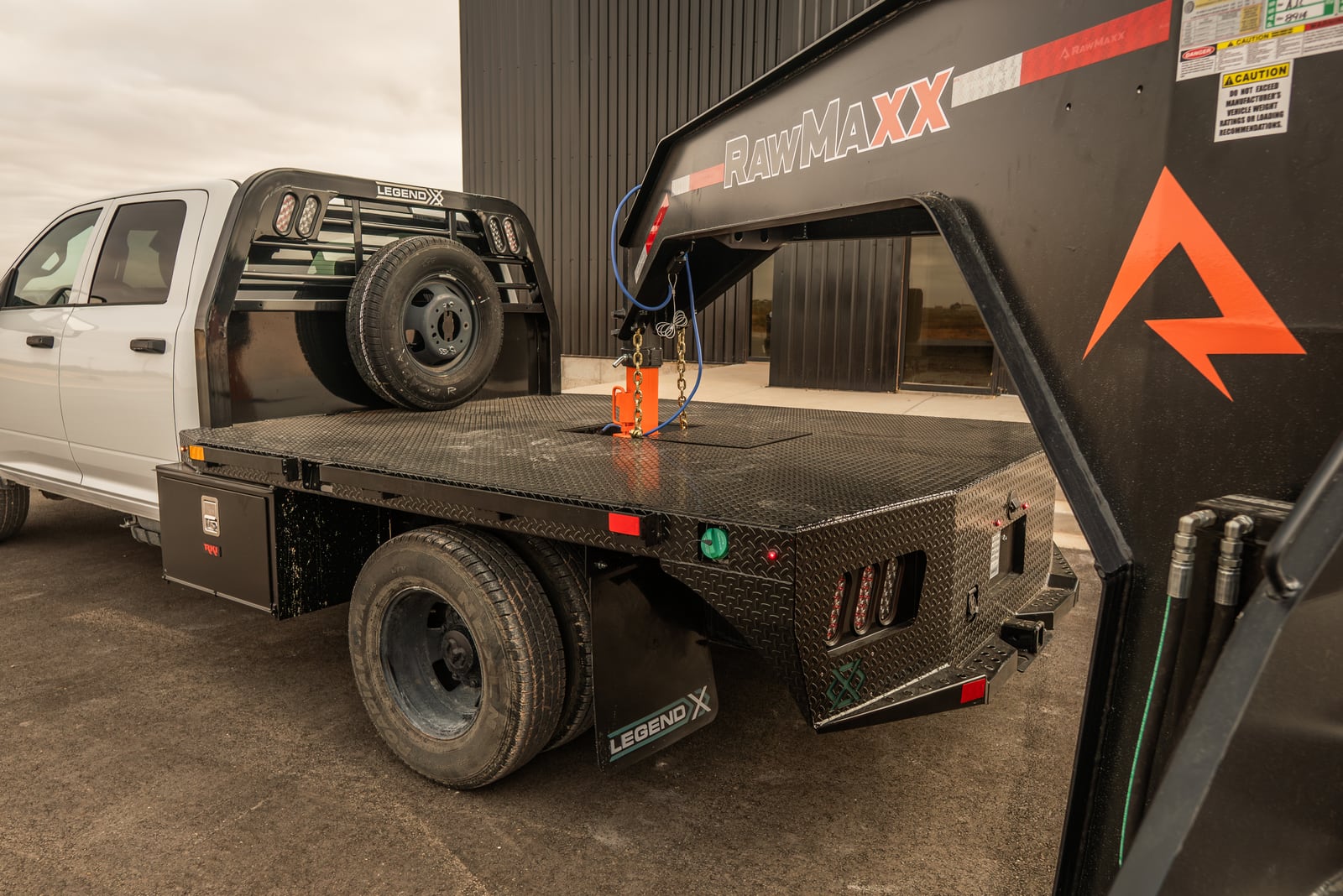 Rear deck and gooseneck area of a black Legend X Spartan flatbed.