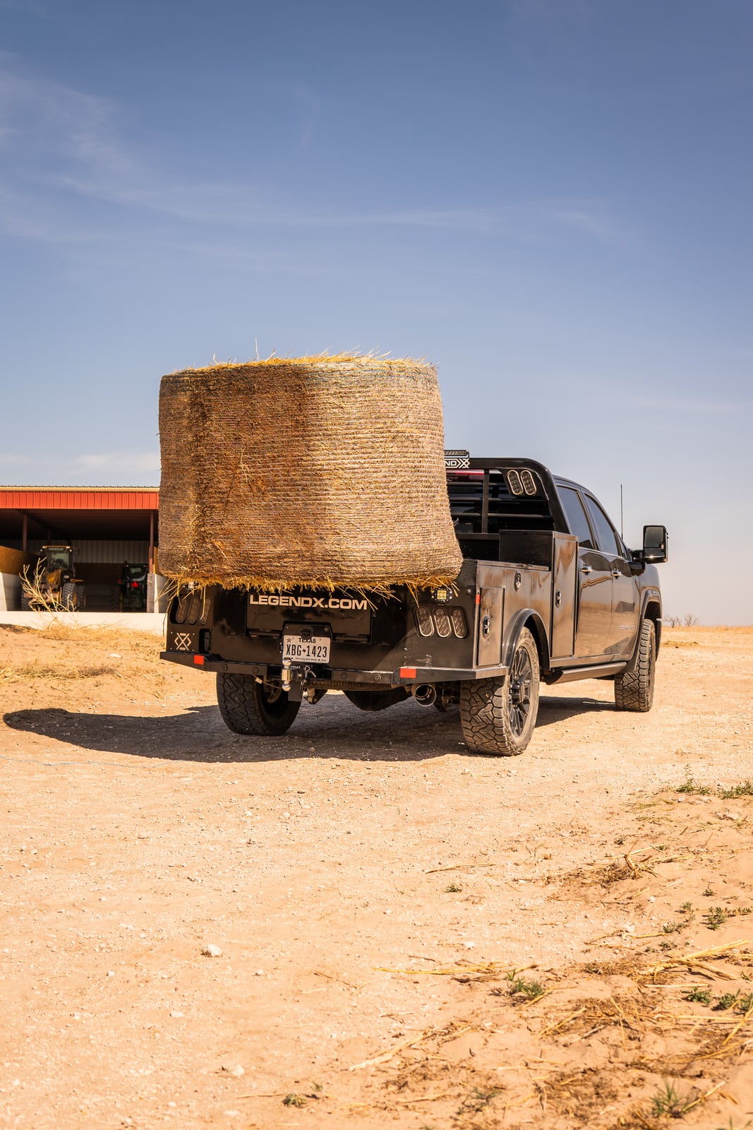 Portrait view of a Legend X spike bed carrying a round hay bale.