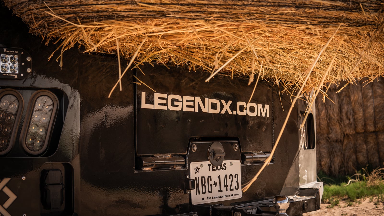 Close rear view of a loaded Legend X spike bed beneath a round hay bale.