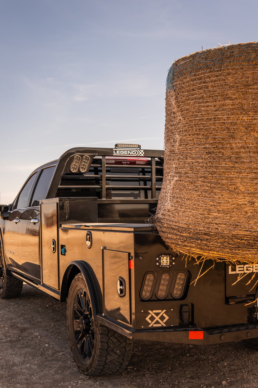 Portrait rear three-quarter view of a Legend X spike bed carrying hay.