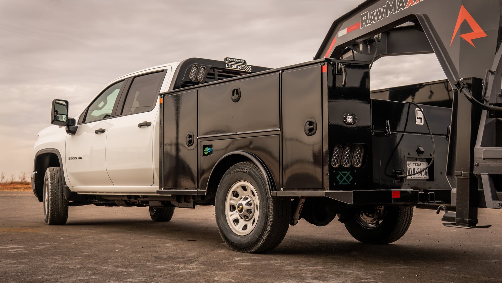 Legend X Titan service body positioned beside a gooseneck trailer.