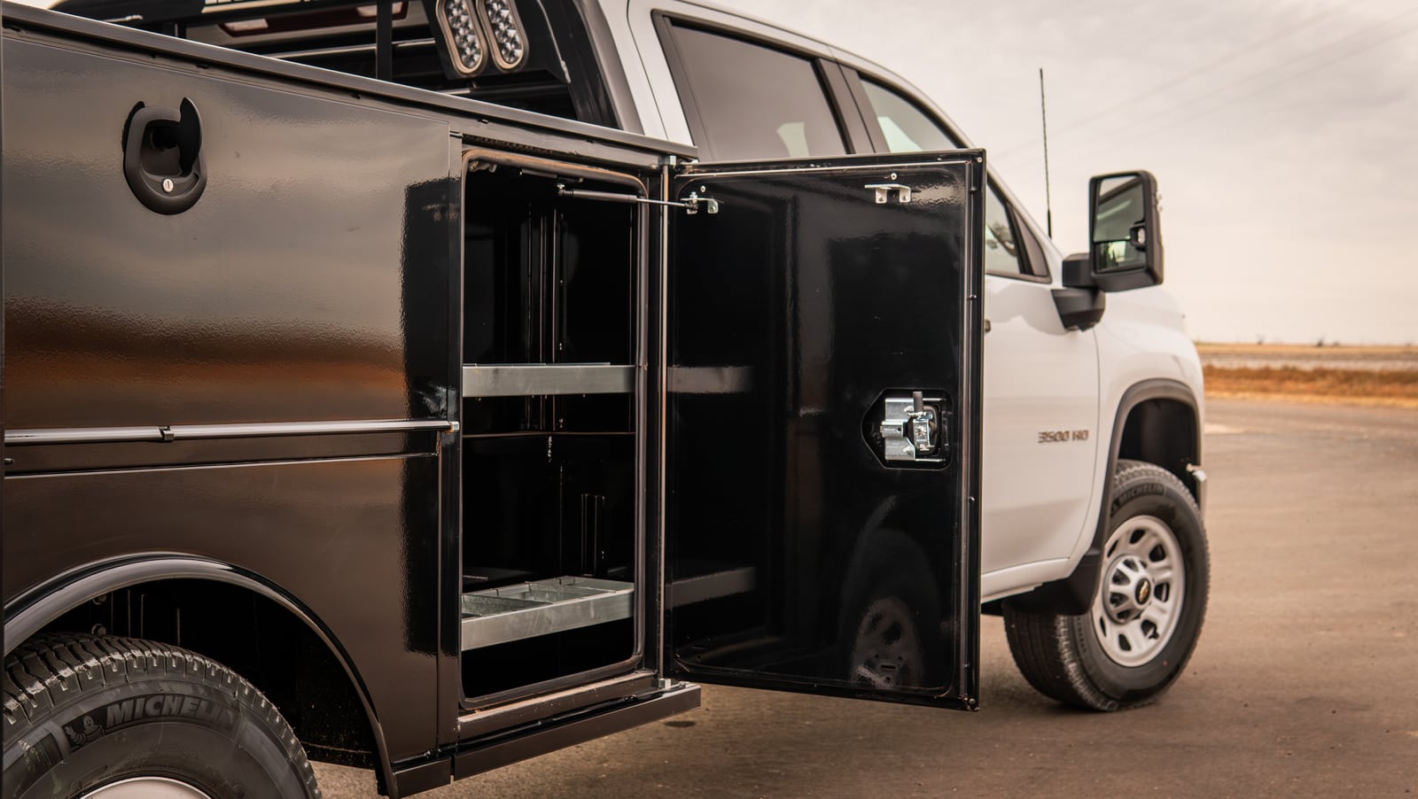 Open side toolbox with shelving on a black Legend X Titan service body.
