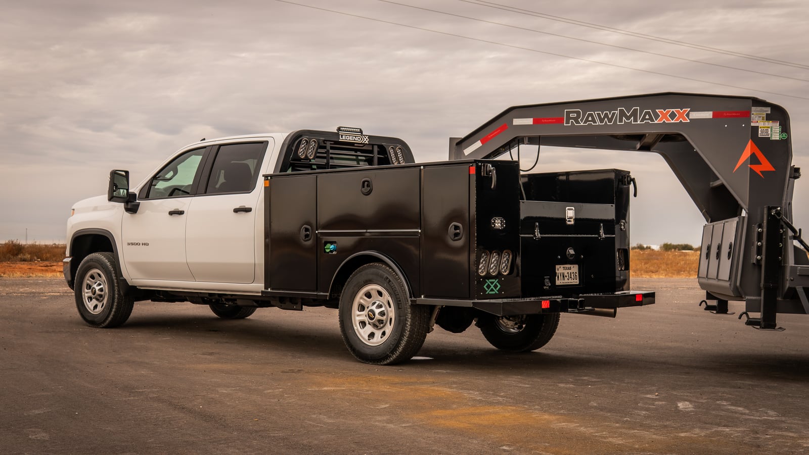 White pickup with a black Legend X Titan service body connected to a gooseneck trailer.