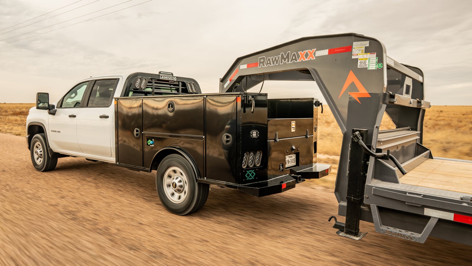 Legend X Titan work truck connected to a gooseneck trailer on a rural road.
