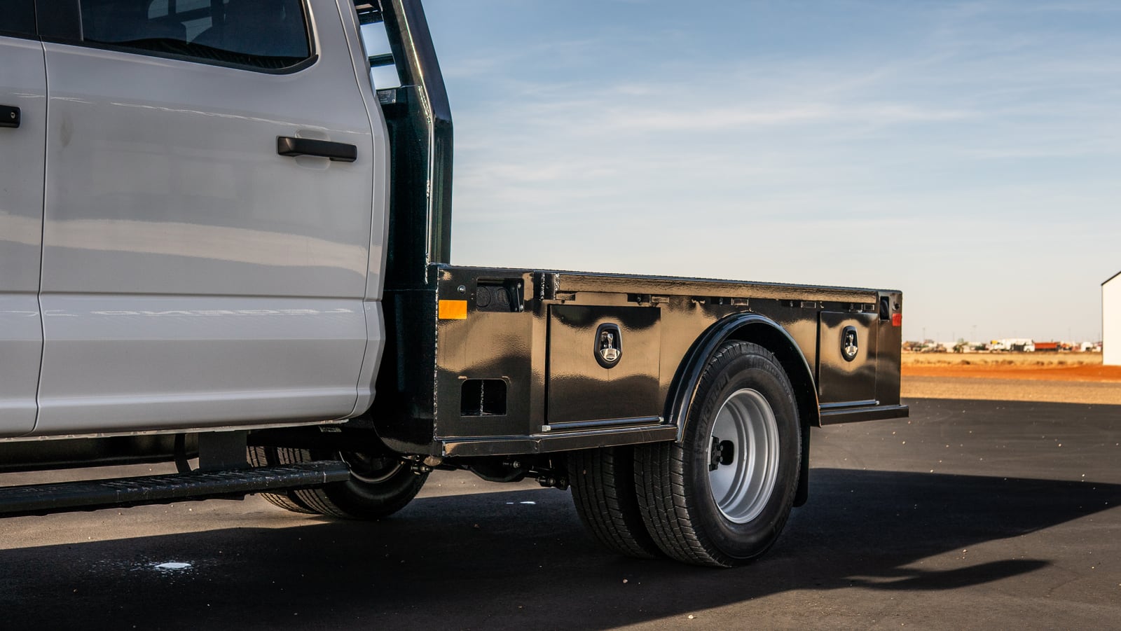 Rear three-quarter view of a black Legend X Viking flatbed.